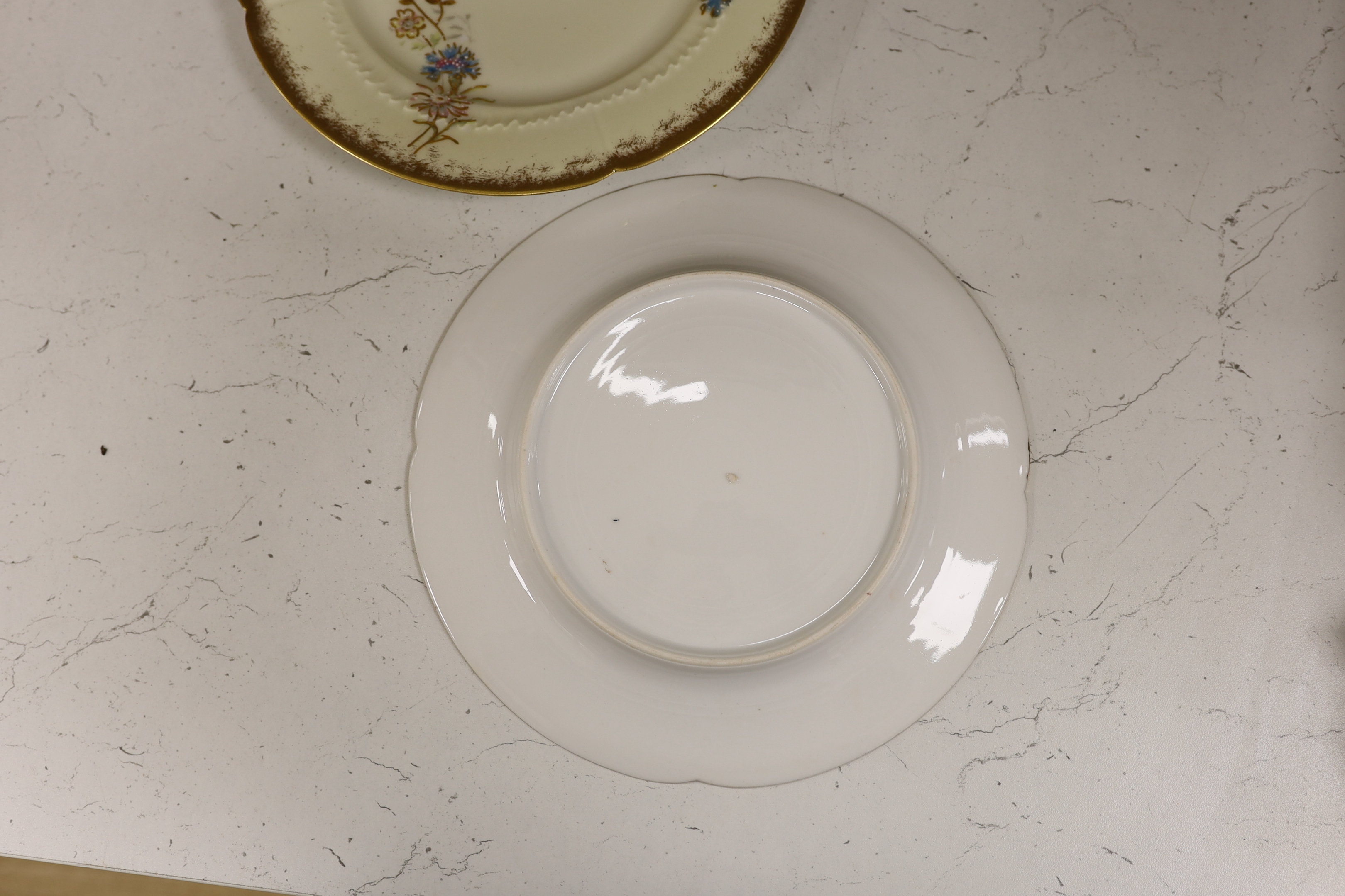 Thirteen Limoges style porcelain dessert plates, two on pedestal bases, gilt decorated with cornflowers etc., 24.5cm diameter